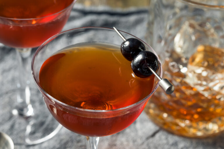 An Old Fashioned cocktail garnished with a skewer of cocktail cherries