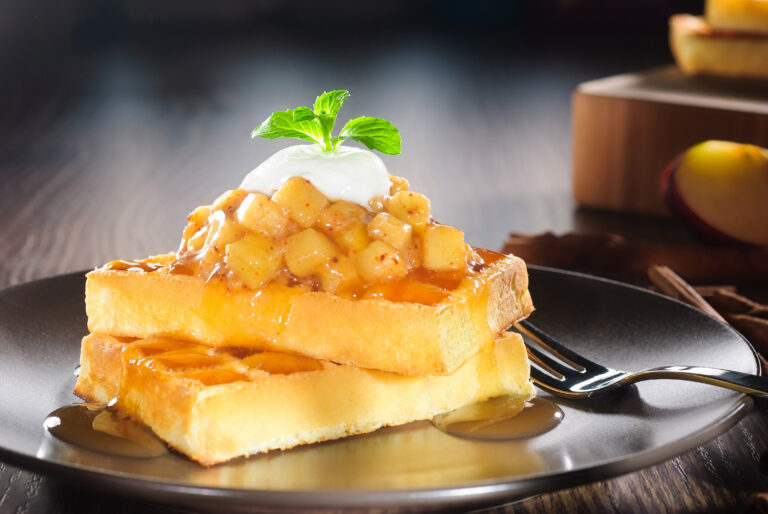 Waffles topped with diced apple, caramel and yoghurt
