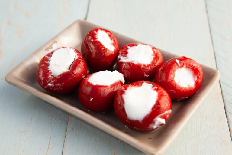 Sweet cherry peppers stuffed with soft cheese, served as a starter