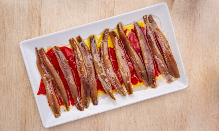 Anchovy fillets in olive oil arranged on a white platter