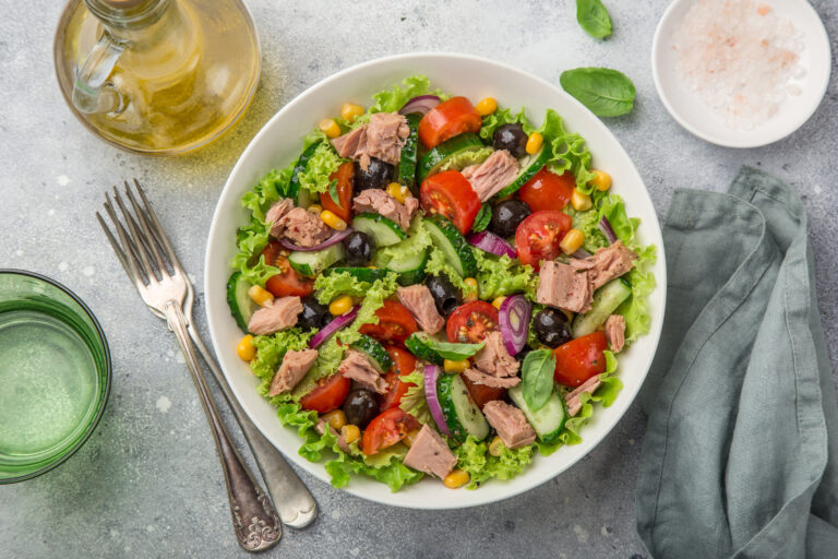 A tuna salad bowl with olives, tomato, cucumber and sweetcorn